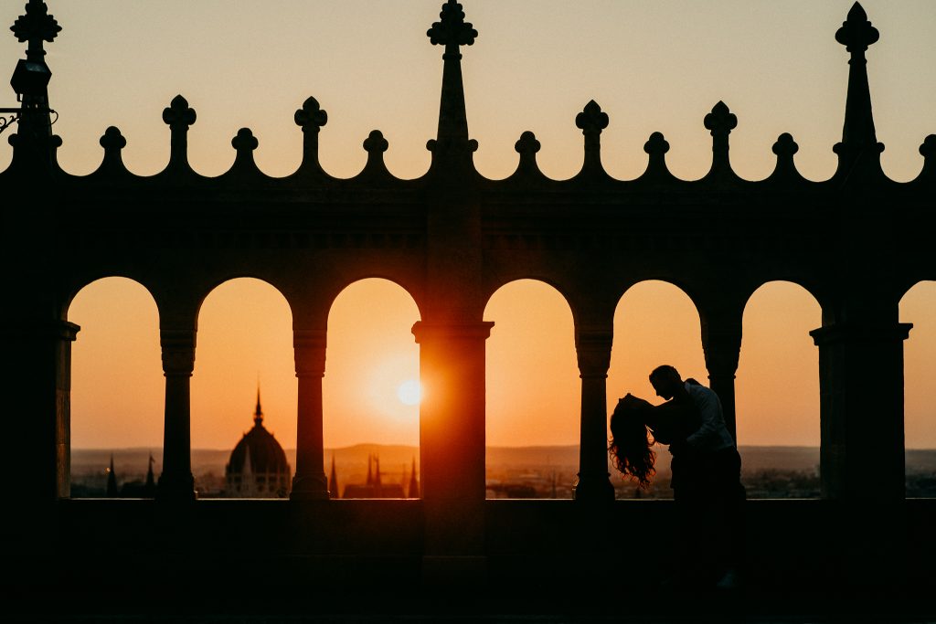 Jegyesfotózás Budapesten: páros a Halászbástya teraszán a Budai Várnegyedben, sziluettes napfelkelte fotó