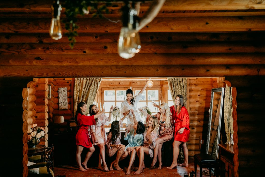 Menyasszony készülődik az esküvő reggelén, sminkelés és öltözködés természetes fényben, meghitt wedding előkészületek fa enteriőrben.