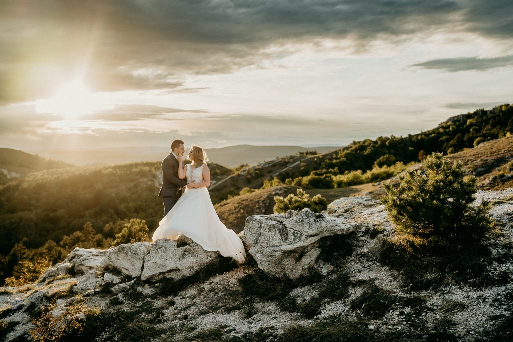 Viki és Tomi kreatív esküvői fotója Budaörs Kőhegyén viharos szélben, természetes, érzelmes és művészi pillanatok