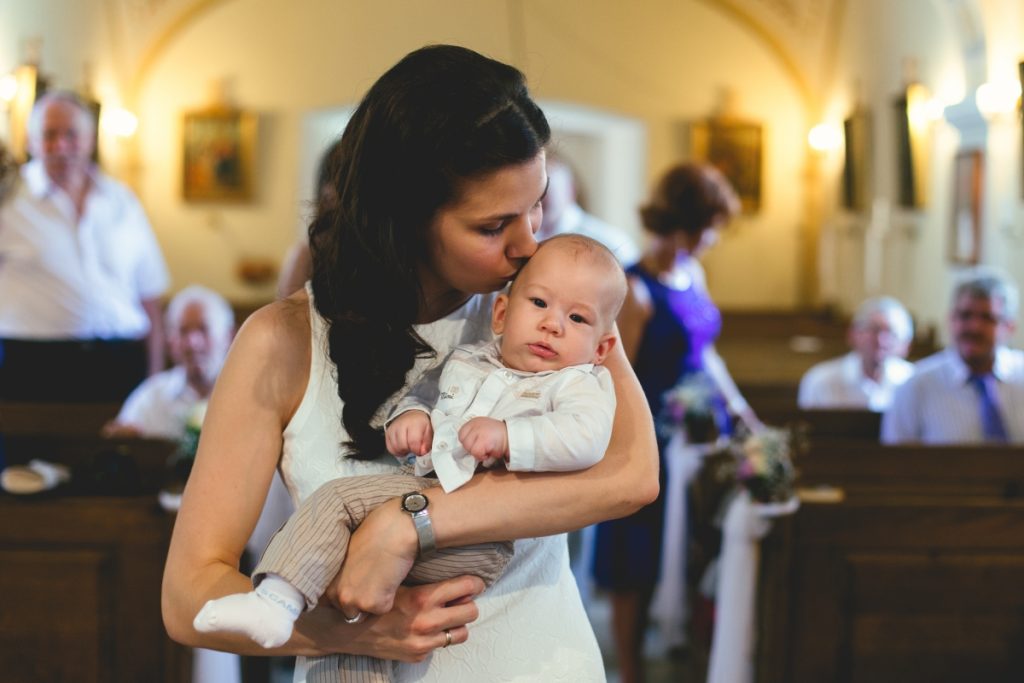 Keresztelő fotózás a kecskeméti Mária-kápolnában, baba és család a templomi szertartás alatt