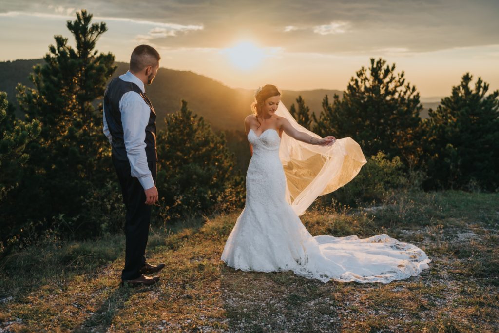 Esküvői pár kreatív fotózáson naplementében, romantikus szabadtéri portré természetes fényben