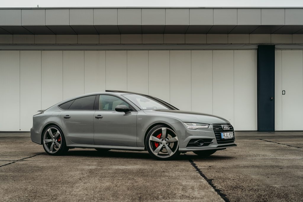 Audi A7 Sportback profi autófotózás Budapest ipari környezetben, szürke falak előtt.